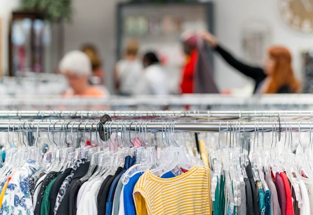 Clothes on rack at Resale Select Store customers in background