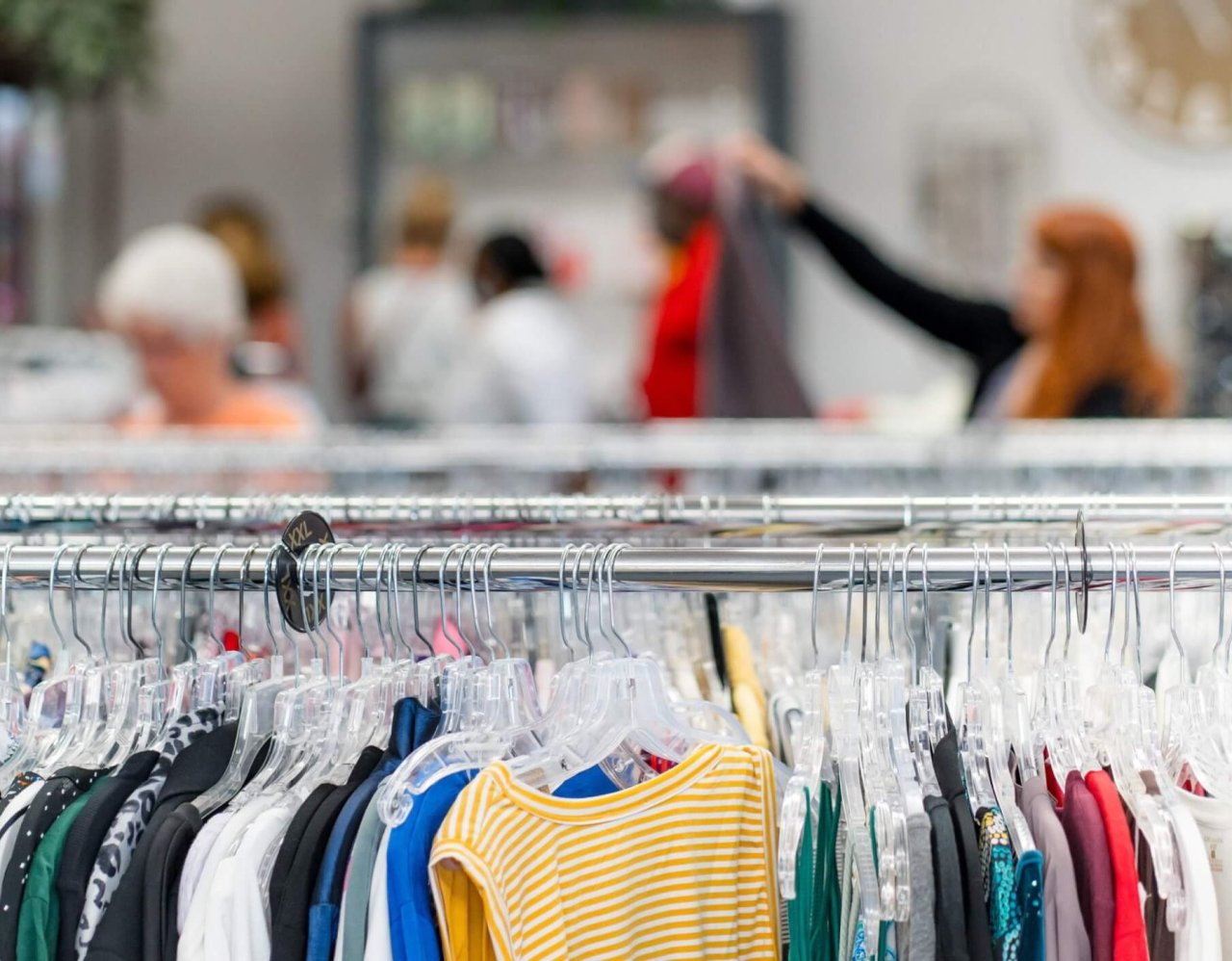 Clothes on rack at Resale Select Store customers in background